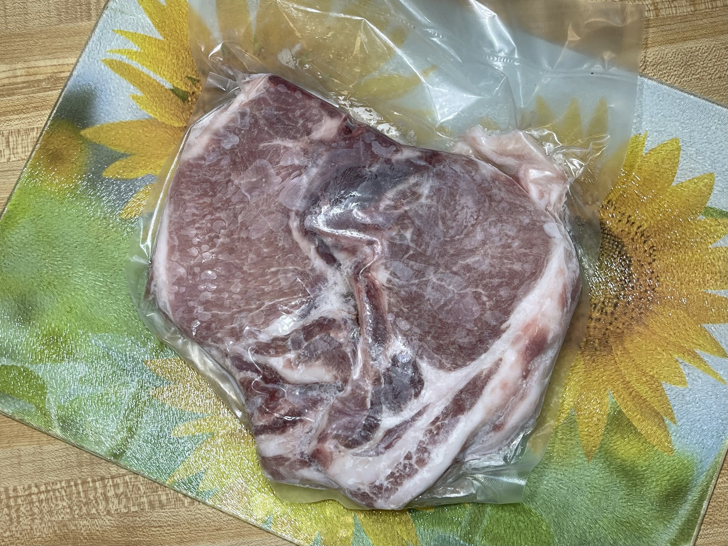 Pork+Chops Succulent pulled pork on a wooden cutting board, showcasing tender, shredded meat with a crispy outer layer. A fork rests beside the meat, highlighting its juicy texture and rich seasoning.