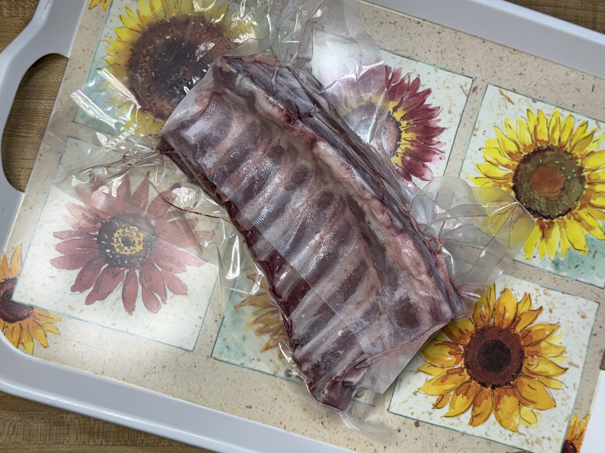 Rack+of+Lamb+Back Succulent pulled pork on a wooden cutting board, showcasing tender, shredded meat with a crispy outer layer. A fork rests beside the meat, highlighting its juicy texture and rich seasoning.